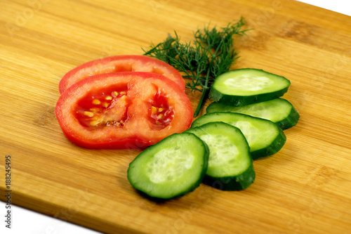 Tomato, cucumber and dill on a wooden board