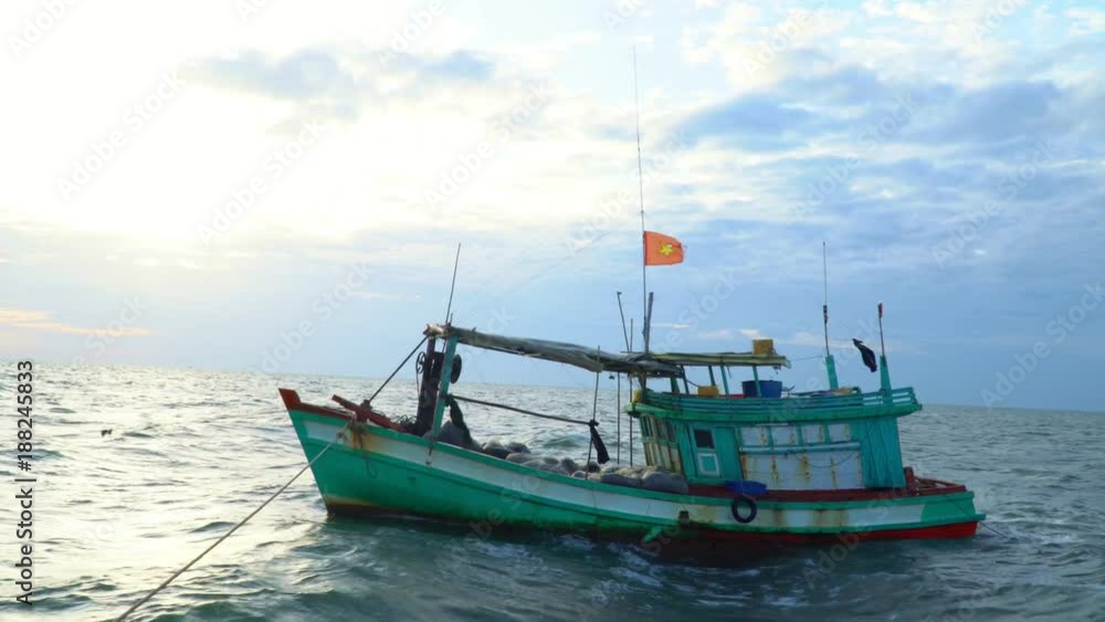 The small boat with the Vietnamese flag costs at a pier. The small boat with the Vietnamese flag costs at a pier.