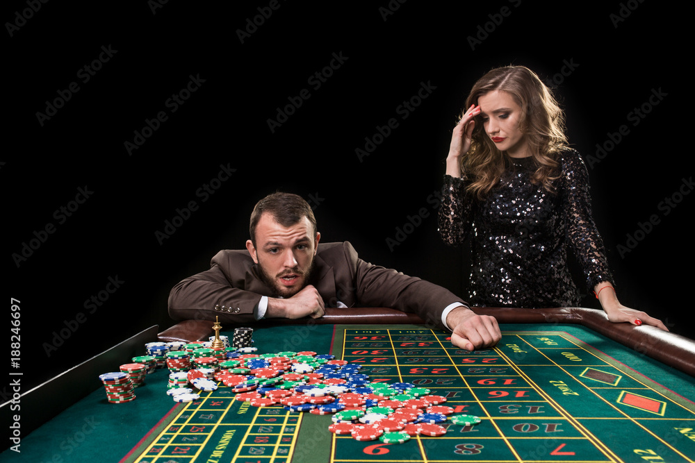 Man and woman playing at roulette table in casino Man and woman playing at roulette table in casino