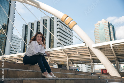 Portraits of beautiful asian woman look cheerful and confidence is sitting in outdoors while feeling success with work.