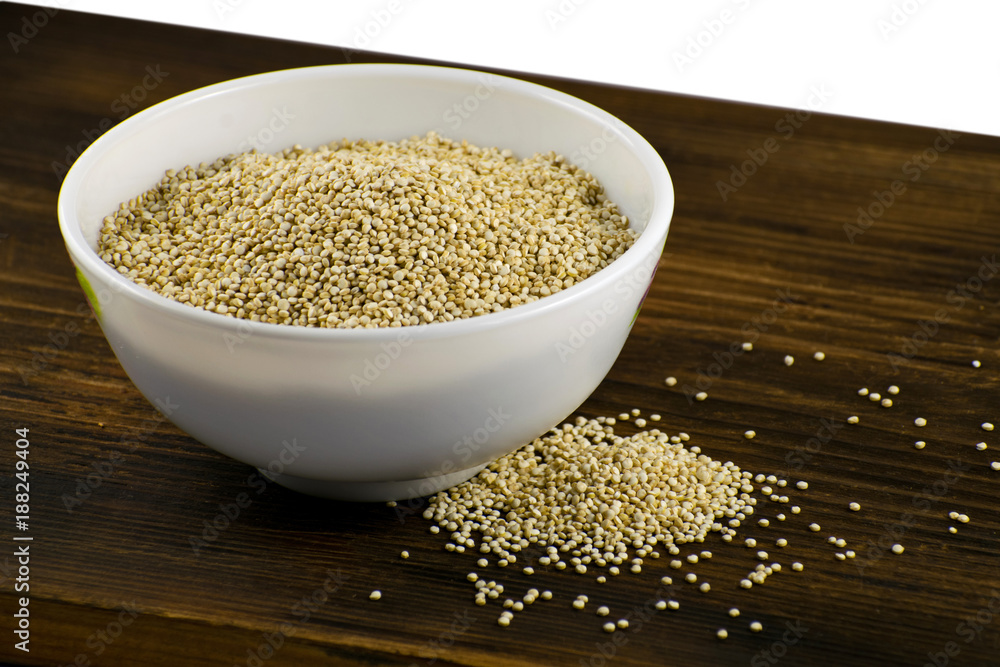 Raw quinoa in a white bowl on a wooden board Raw quinoa in a white bowl on a wooden board