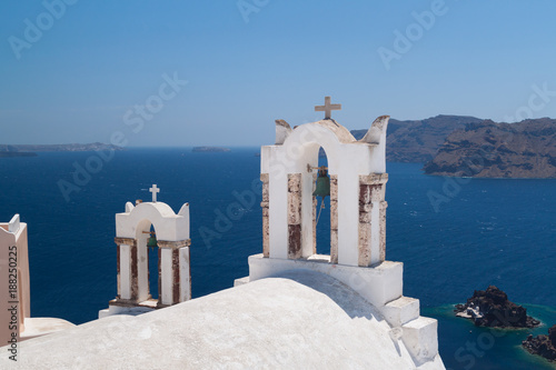 Bell tower of church above blue bay at Santorini,Greece