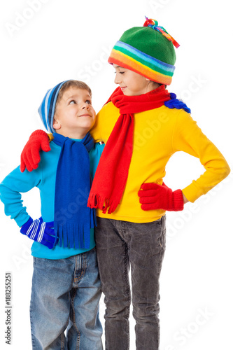 Two smiling kids in winter clothes standing together
