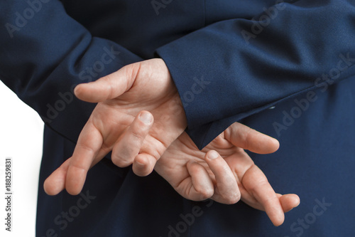 Tableau sur toile Closeup of a business man with his hands behind his back and fingers crossed