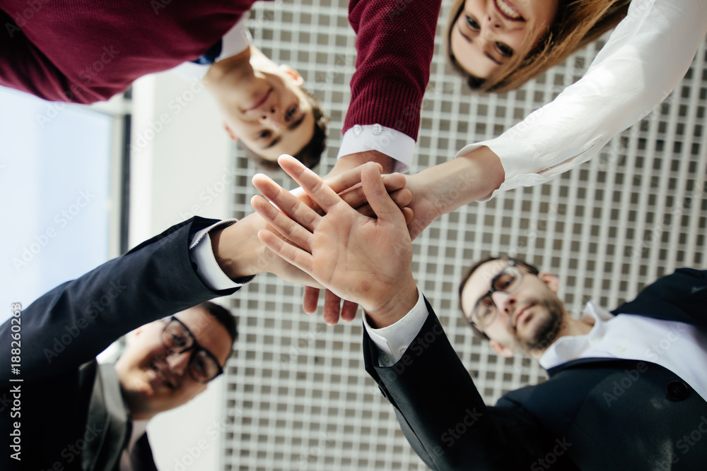 Close-up of business partners making pile of hands at meeting. Team work. Close-up of business partners making pile of hands at meeting. Team work.