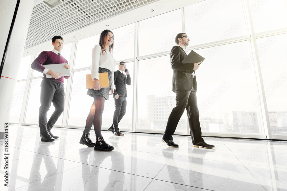 Business people walking in the office corridor. Walk team. Business people walking in the office corridor. Walk team.