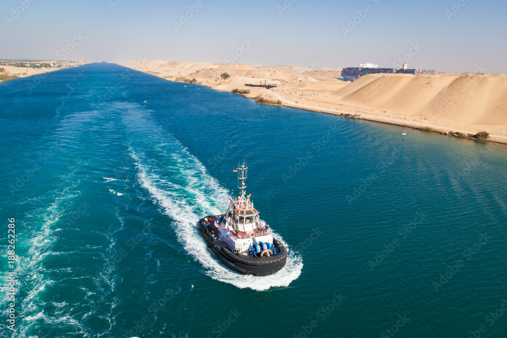 Tugboat behind a cruise ship on Suez canal, Egypt