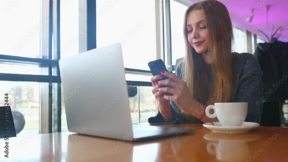Woman typing text message on smart phone in a cafe. Young woman sitting at a table with a coffee using mobile phone. With blank copy space scree for your advertising text message or promotional Woman typing text message on smart phone in a cafe. Young woman sitting at a table with a coffee using mobile phone. With blank copy space scree for your advertising text message or promotional
