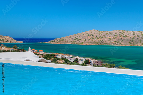 Blue swimming pool with Mirabello Bay view on Crete, Greece