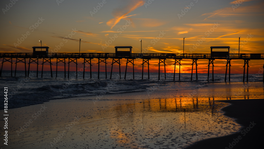 Colorful Sunset at ocean coast with silhouette of pier and photographer Colorful Sunset at ocean coast with silhouette of pier and photographer