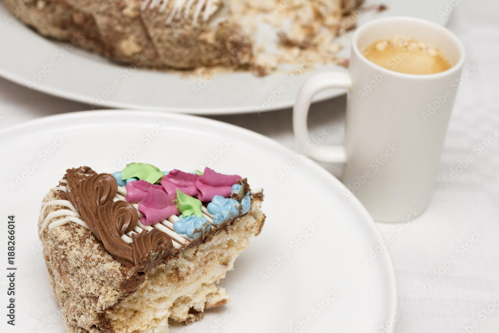 Cake with cream, nuts and meringue with cup of coffee Cake with cream, nuts and meringue with cup of coffee