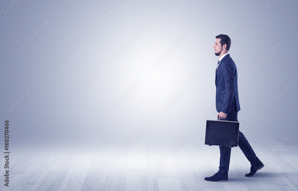 Businessman walking in front of an empty wall Businessman walking in front of an empty wall