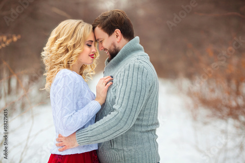 beautiful young couple in love, in light sweaters, walking in the park in cold weather