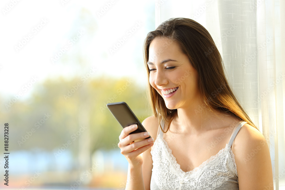 Woman reading phone message in the morning Woman reading phone message in the morning