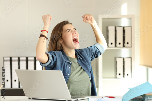 Excited intern celebrating success at office photo