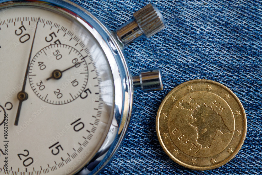Fototapeta premium Euro coin with a denomination of fifty euro cents (back side) and stopwatch on worn blue denim backdrop - business background