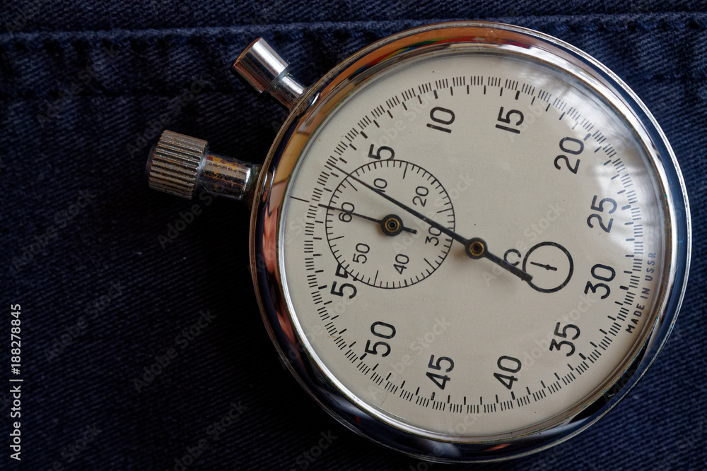 Stopwatch on dark blue jeans background, value measure time, old clock arrow minute and second accuracy timer record Stopwatch on dark blue jeans background, value measure time, old clock arrow minute and second accuracy timer record