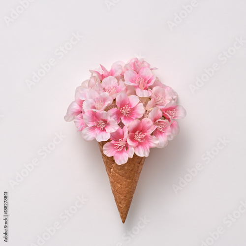 Ice Cream Cone with Bouquet of Flowers. Spring Summer Floral concept. Creative Minimal. Pink Blossom, Vanilla Color. Trendy fashion Style. Art