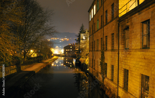 hebden bridge at night showing canal with the buildings of the town glowing in the distance