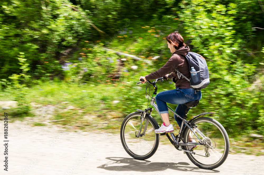 Young Woman Riding a Bicycle on a Sunny Spring Day. Blurred Motion. Young Woman Riding a Bicycle on a Sunny Spring Day. Blurred Motion.