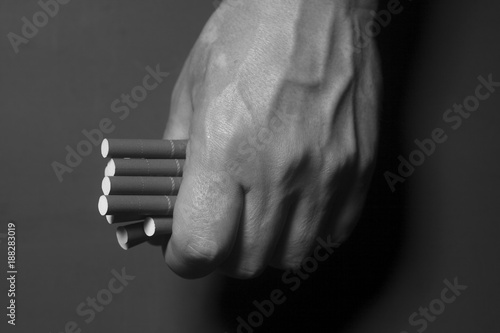Tobacco addiction. Cigarettes on man hand.