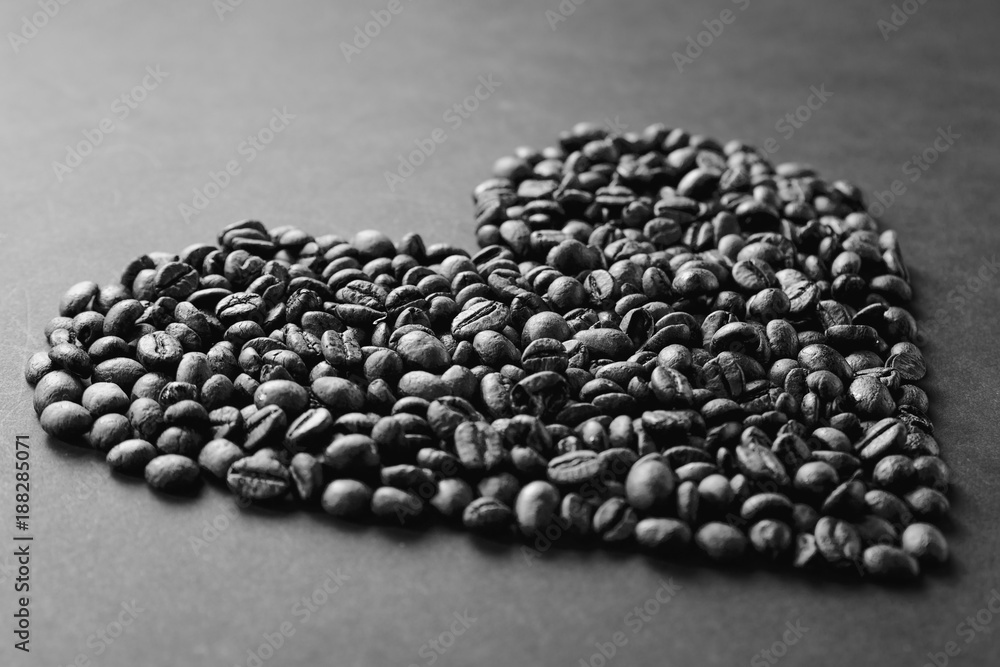 Black and white coffee beans in form of heart isolated on gray texture background for design. Saint Valentine's Day card on fabruary 14, holiday concept. Black and white coffee beans in form of heart isolated on gray texture background for design. Saint Valentine's Day card on fabruary 14, holiday concept.