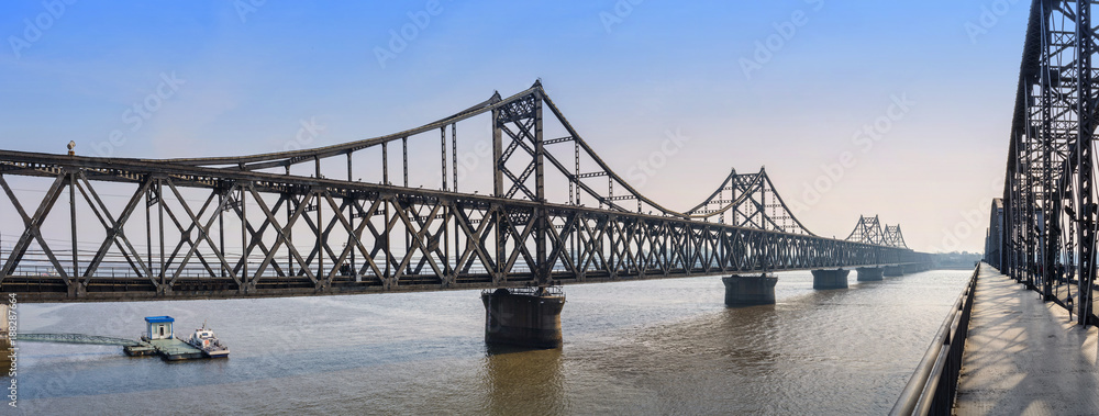 Naklejka premium Yalu River Bridge. In the distance is North Korea. Located in Dandong, Liaoning, China.