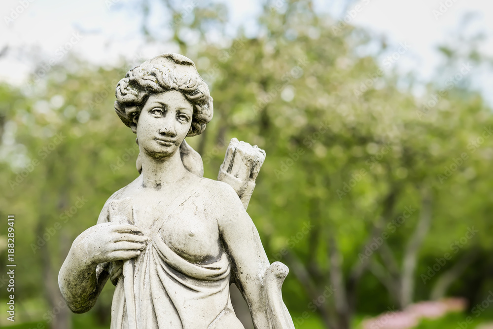 Diana, goddess of hunt, moon, and nature, female hunter with bow and arrow. Old white sculpture
