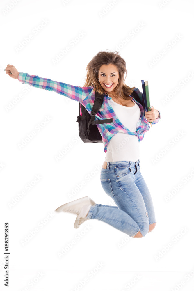 Happy female student jumping with her books and backpack Happy female student jumping with her books and backpack