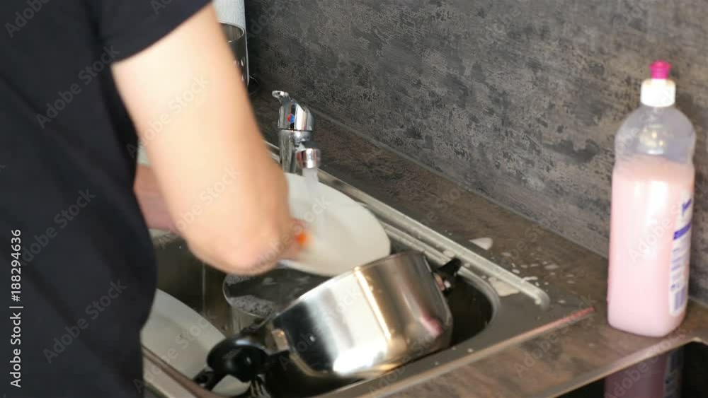 Video of man washing dishes in the kitchen in 4K Video of man washing dishes in the kitchen in 4K