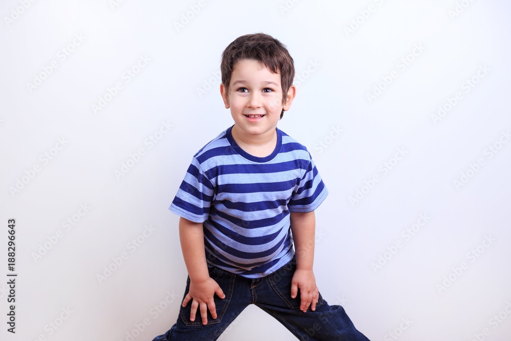 Little lovely boy smiling and posing, studio shoot on white. Emotions, feelings, states of mind, childhood concept Little lovely boy smiling and posing, studio shoot on white. Emotions, feelings, states of mind, childhood concept