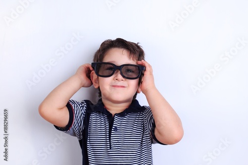 Happy lovely smiling boy in sunglasses  studio shoot on white. Children  fashion and lifestyle concept