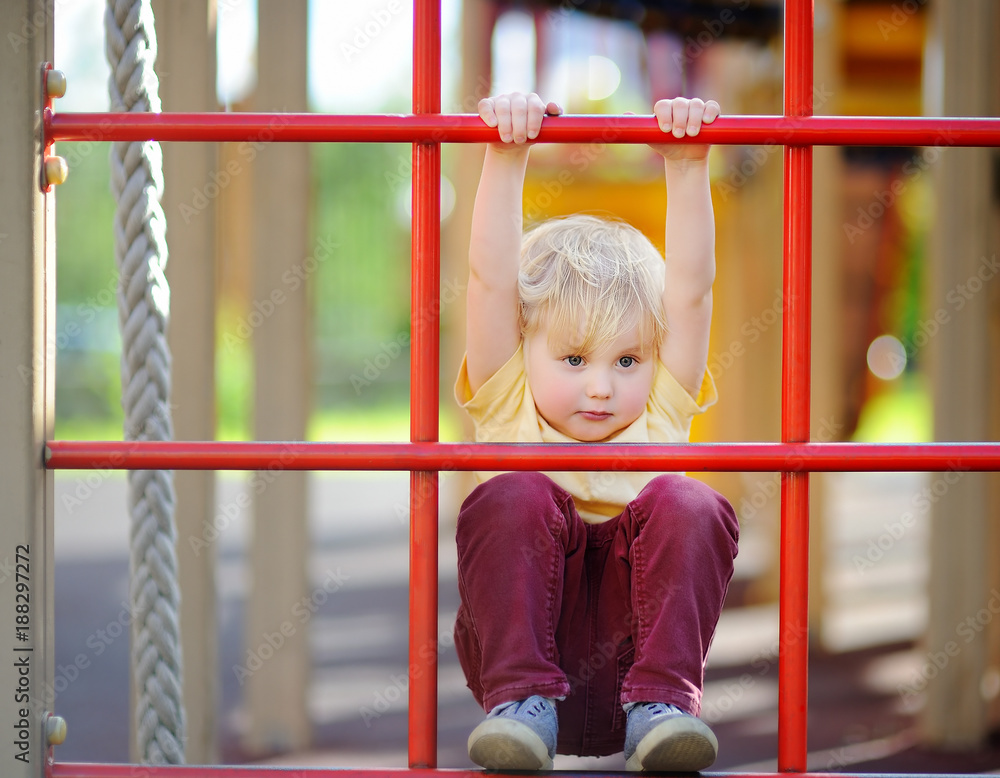 Fototapeta premium Little boy having fun on outdoor playground