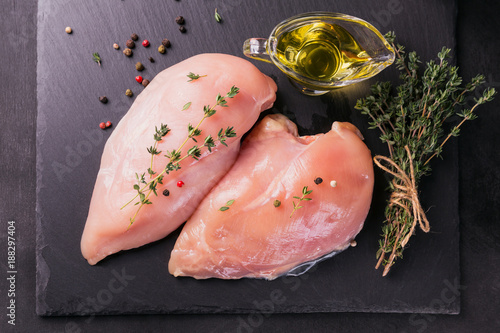 Raw chicken fillets with spices and herbs.