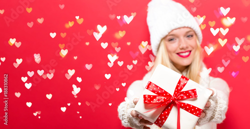 Young woman holding a gift box with heart lights photo