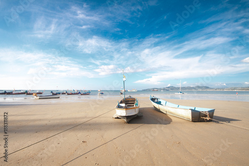 Boat on the beach with blue sky.