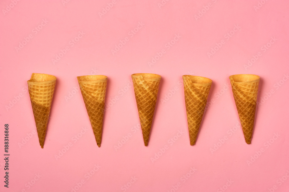 Empty ice cream cornet on pink background. Flat lay style.