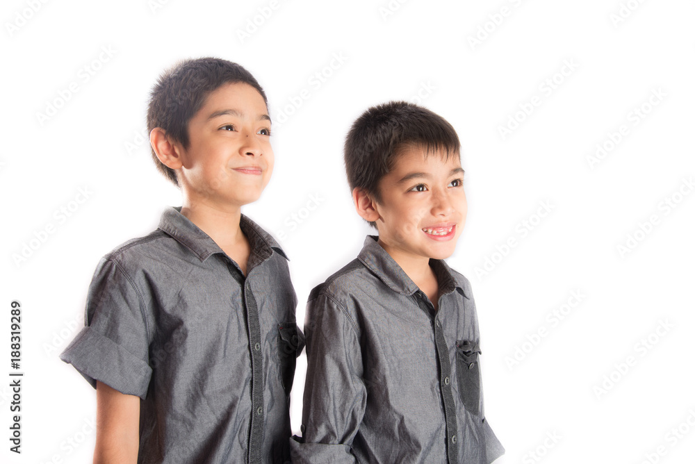 Little sibling boy standing together looking side of the flame with smile Little sibling boy standing together looking side of the flame with smile