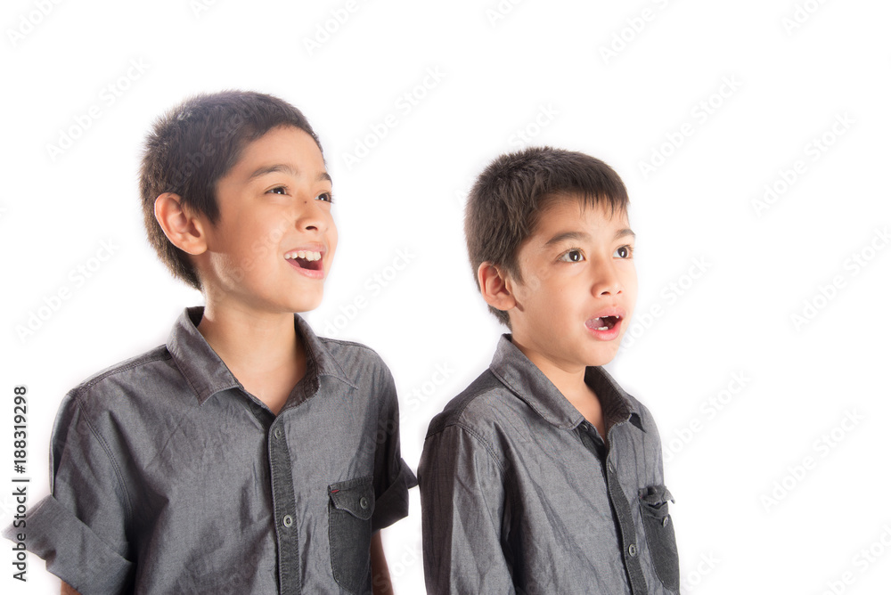 Little sibling boy standing together looking side of the flame with smile Little sibling boy standing together looking side of the flame with smile