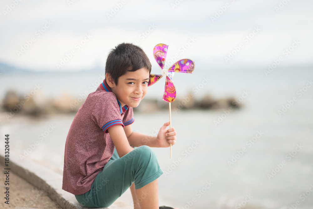 Little boy playing turbine wind toy at the beach Little boy playing turbine wind toy at the beach