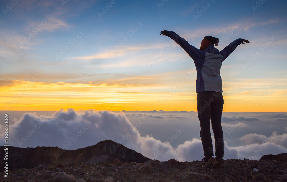 Happy girl jumping on the mountain in sunset time Happy girl jumping on the mountain in sunset time