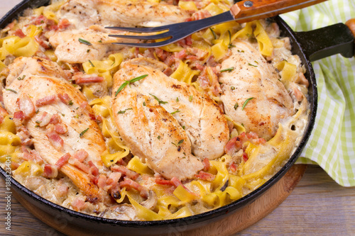 One pan chicken, bacon and mushrooms with egg noodles in frying pan, horizontal