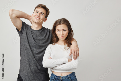 Photo of dissapointed girlfriend and boyfriend who do not care. Woman is concerned about relationship with this guy. He thinks only about himself. Maybe there is hope and he will change.