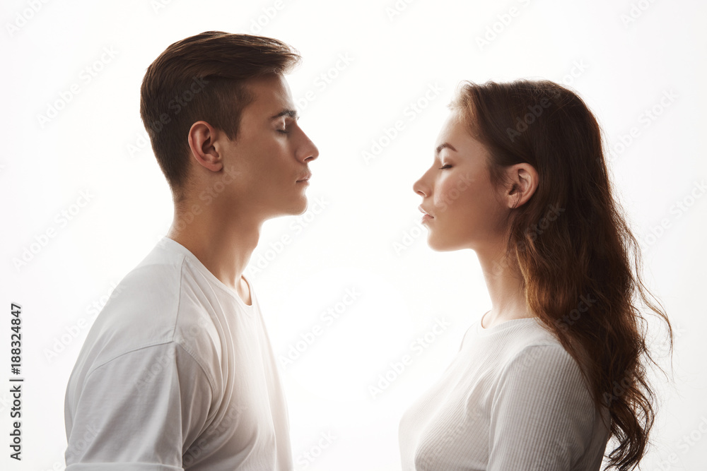 Young woman and man in love standing with closed eyes. Love is in the air, those who jealous, try not to breathe. They do not care about the rest, because in their universe only two of them exist. Young woman and man in love standing with closed eyes. Love is in the air, those who jealous, try not to breathe. They do not care about the rest, because in their universe only two of them exist.