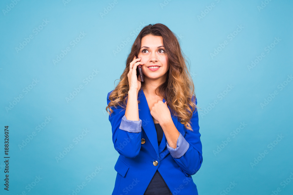 Smiling woman talking on the smart phone on blue background Smiling woman talking on the smart phone on blue background