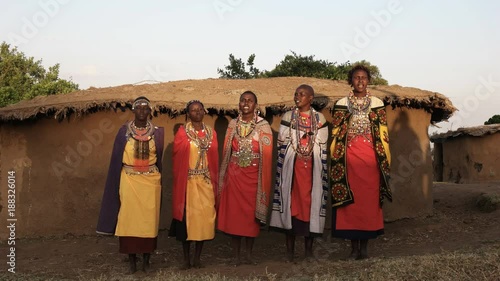 wide shot of a group of maasai women singing in enkereri village near masai mara, kenya photo