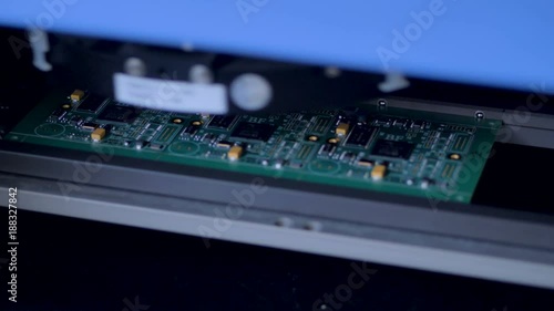 Automated modern machine producing electronic circuit board. Robotic equipment install electronic components and chips on circuit board.