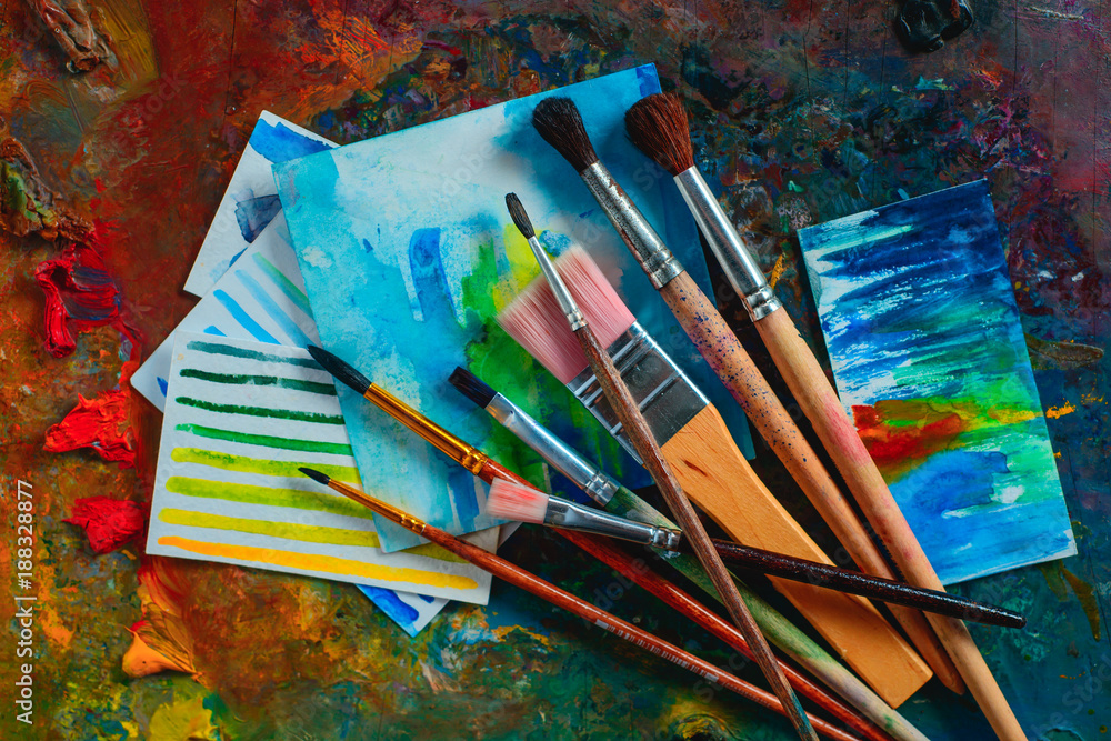 Header with an oil palett, brushes, paints and sketches. Artist tools on a dark background with copy space. Creative occupation concept. Header with an oil palett, brushes, paints and sketches. Artist tools on a dark background with copy space. Creative occupation concept.