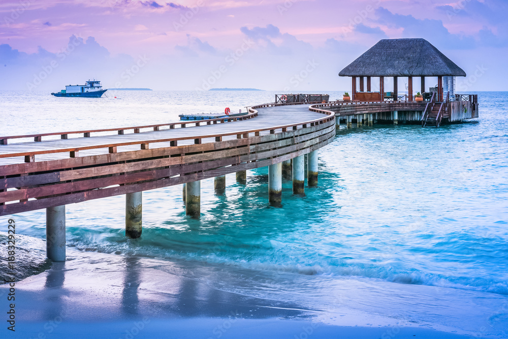 Wooden pier and blue sea at Maldives in sunset