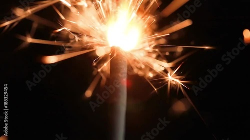 brennende Wunderkerze in Nahaufnahme mit schwarzem Hintergrund